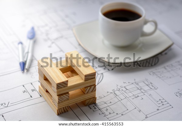 Model house\
from wooden blocks (bars), coffee cup, dividers at the drawings.\
Soft focus with lights\
effects.