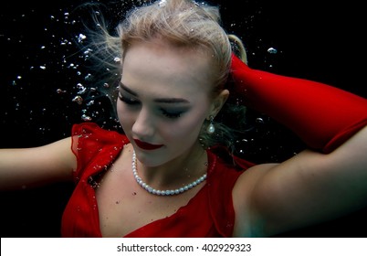 Model Looking Down Underwater With Pearl Necklace