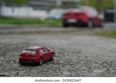 model mazda 3 car from HotWheels with a real japanese Mazda 3 car in red colour