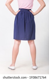 Model In A Navy Blue Skirt And A Pink Blouse On A Light Background.