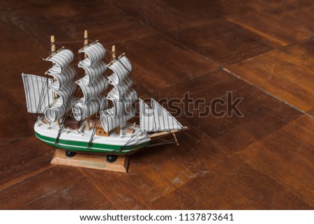 model of an old sailing ship on a scratched wooden surface. Beautiful miniature ship. Wooden ship figurine. Antique model sailing ship isolated with clipping path.

