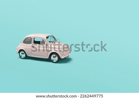 Model pink retro toy car on green background. Miniature car with copy space