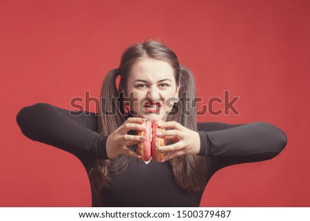 Model plus size with sweet donut, happy girl smiling holding in hands donuts and push them, in black bodysuit. XXL female on red background
