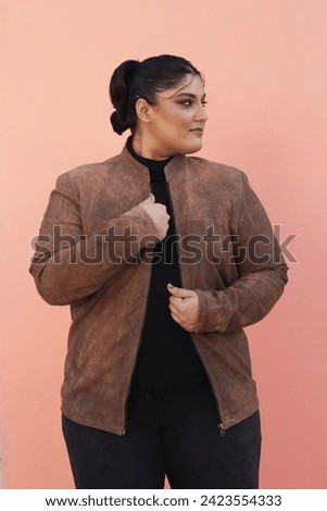 model posing in brown leather jacket with black jeans and top 