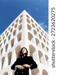 the model posing in front of the camera in front of a period building