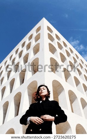 the model posing in front of the camera in front of a period building