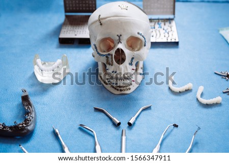The model of the skull for maxillofacial surgery and dentistry lies on a table with plates screwed into it.