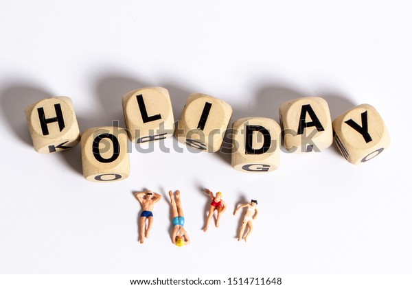 Model toy figure and\
holiday words for travel concept, Isolate words and figure model on\
white background 