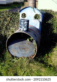 A Model Train Engine Made From An Old Oil Drum, Now Rusty And Neglected On A Grass Verge In West Wales, UK.