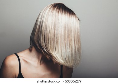 Model With Unrecognizable Face With Blond Shiny Hair. Woman Bob Haircut Styling.