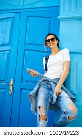 Model Wearing Plain White T-shirt, Boyfriend Jeans, Sneakers And Hipster Sunglasses Posing Against Street, Teen Urban Clothing Style.