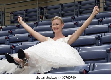 Model Wearing Wedding Gown Cheering In A Baseball Stadium.