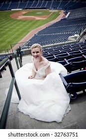 Model Wearing Wedding Gown Posed In A Baseball Stadium.