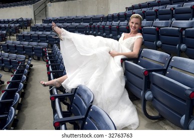 Model Wearing Wedding Gown Posed In A Baseball Stadium.