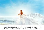 Model in White Dress Flying on Wind. Happy Woman Enjoying Sun looking away at Blue Sky. Carefree Girl dreaming at Sea Beach Resort. Freedom and Spiritual Relax Concept