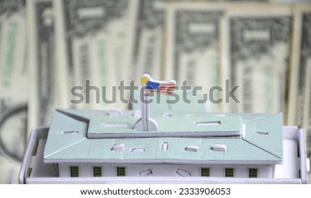 model of a white house against the background of us dollars, a flag is installed on the roof. residence of the President. the capital of country. dollar hegemony in the global financial market