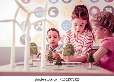 Model of wind farm. Curious little scientists sitting in class and exploring alternative energy using wind turbines as an example - Powered by Shutterstock