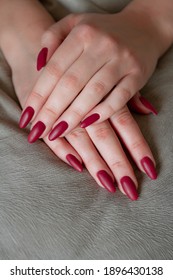 Model woman showing red shellac manicure on the long nails