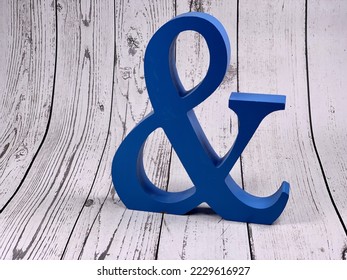 A model of a wooden three-dimensional "and" character. Ampersand blue background. 3D ampersand. And letter decoration. Design and typography.