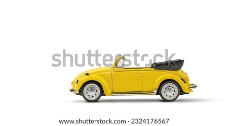 Model of yellow retro toy car cabriolet on a white background. Miniature car side view