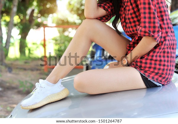 \
The model\'s\
beautiful legs sit on the\
car.