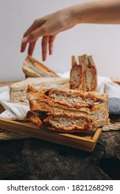 The Model's Hand Was Picking Up The Homemade Sandwich. Made From Whole Grain Bread Stuffed With Minced Pork, Onions And Chili Sauce Placed On A Wooden Tray.