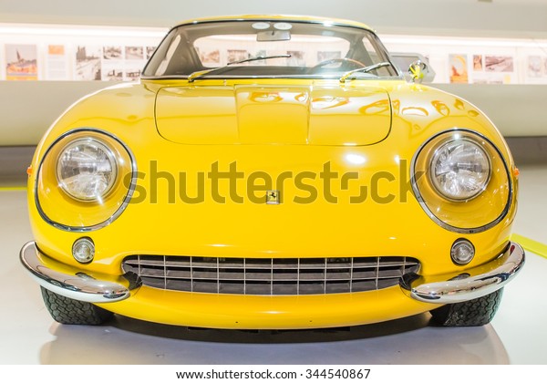 MODENA, ITALY - APRIL 2015:\
Museum Enzo Ferrari Modena. Yellow Ferrari 275 GTB 4 1966 with The\
Cavallino Rampante (Ferrary horse), symbol of Ferrari on hood.\
Front view.