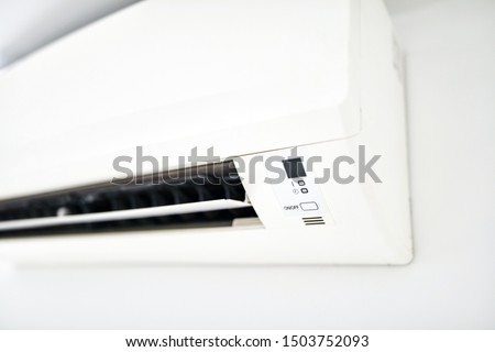 Moder air condition unit on a white wall inside the living room.