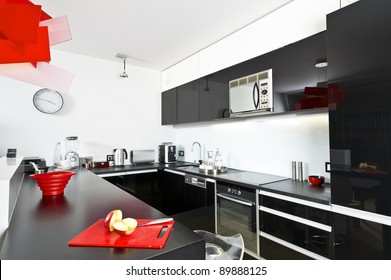 Moder Black And White Kitchen Interior With Red Lamp