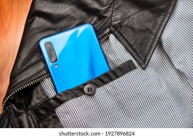 Modern 3d camera smart phone in  jacket pocket. Top view of blue gadget, horizontal orientation