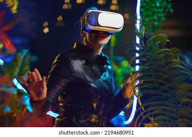 Modern 40 Years Old Woman In Metaverse In Vr Headset Exploring.