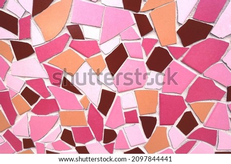 Modern abstract mosaic background pattern in a bright bold palette of pink, orange, brown, magenta, ochre, white glazed tile fragments of different shapes and sizes