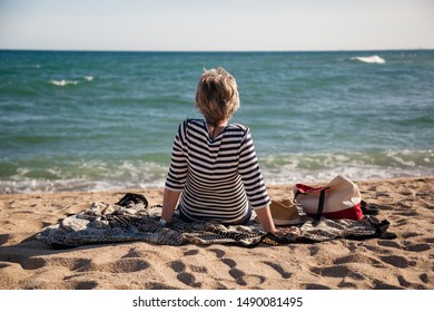 Modern Active Senior Woman Sitting On The Beach Alone Enjoying The Great View, Concept Freedom, Autonomy