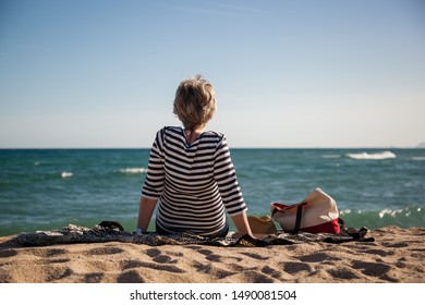 Modern Active Senior Woman Sitting On The Beach Alone Enjoying The Great View, Concept Freedom, Autonomy