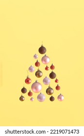 Modern aesthetic with Christmas tree shape made of colorful baubles against bold yellow background. Minimal New Year concept. Holiday spirit visual. - Shutterstock ID 2219071473