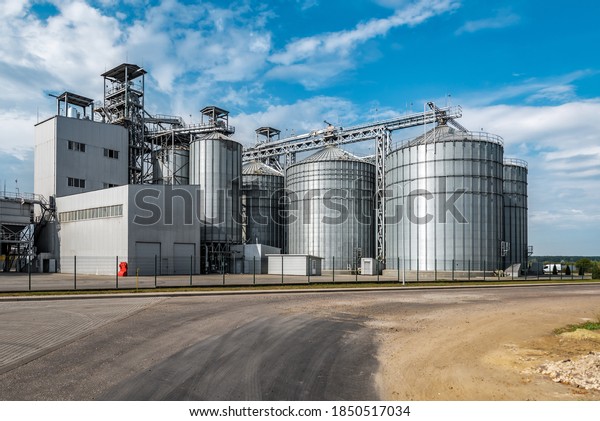Modern agricultural silos or grain elevator\
with blue sky on the background. Storage of grain and other\
different cereals. Sunflower oil\
factory