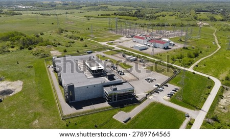 Modern AI data center facility expanding across a green rural landscape, integrating high voltage electrical substation infrastructure for substantial power supply and data processing
