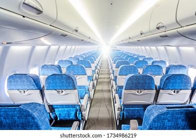 Modern Airplane Cabin Interior With Empty Economy Class Seats. Wide Back Side Inside View Of Jet Plane Passenger Compartment. Aircraft Transportation Background. Air Travel Concept