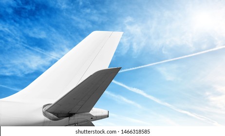 Modern Airplane Tail Isolated On Cloud Sky Background Side View Of Commercial Passenger Jet Aircraft With Wide Body Cargo Plane Parts Like White Fuselage Fin Wing Air Travel Copy Space Template