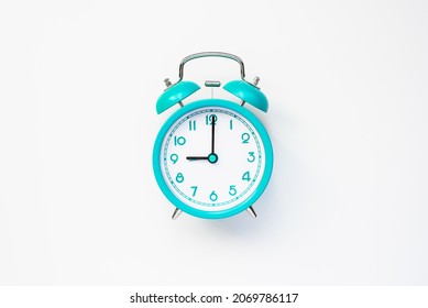 Modern alarm clock in retro style on cyan color batteries isolated on white background. Time and morning concept. Flat lay