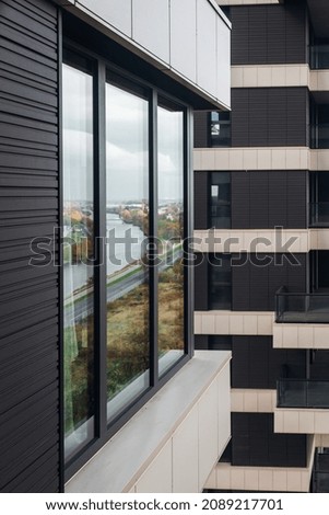 Modern apartment with cozy balcony vertical view. Skyscraper close up view