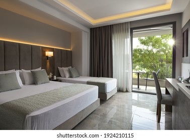 Modern Apartment Interior Of Family Hotel Room With Grey Oak Wood Furniture, Single, Double King Size Bed. Contemporary Bedroom With Open Big Window, Green Garden Sunset View Door