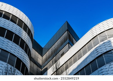 Modern Architectural Design with Curved and Angular Facades Against a Bright Blue Sky