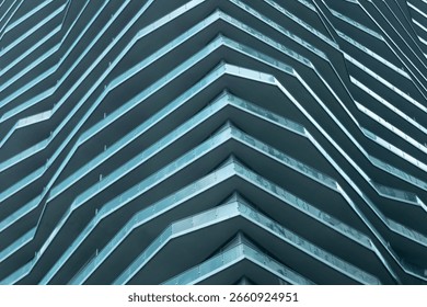 Modern architectural design showcases angular patterns and glass balconies in an urban setting during daylight hours