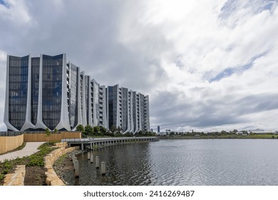 Modern architecture apartment buildings with a tulip design style on a curved waterfront shoreline on an artificial lake with overcast sky on the Gold Coast in Queensland, Australia. - Powered by Shutterstock