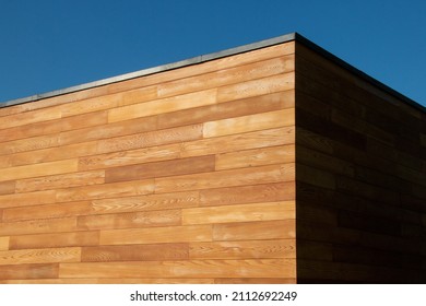 Modern Architecture detail of red cedar cladding wood facade, geometric shape, minimalist esthetics