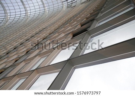 Modern architecture elements. Metal grid and structural glazing with reflections. Grid structure. Abstract construction industry background combining curvilinear and angular shapes.