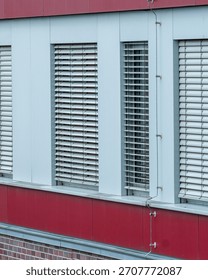 Modern architecture featuring rows of white venetian blinds on an office building, providing privacy and shade