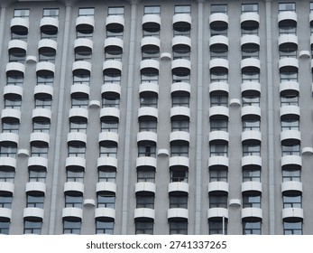 Modern Architecture Geometric Window Pattern. Symmetrical facade of high rise building with repetitive curved balconies and windows. Minimal urban architecture texture and geometric background.