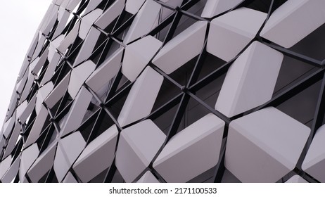 Modern architecture. Panels like honeycombs, unusual panels. Geometric shape. Part of a modern building. The building is assembled from geometric panels of hexagonal shapes - a hexagon. On a white bac